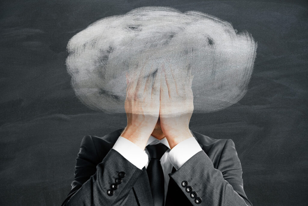 Persona che si copre il viso sopraffatto da ansia e preoccupazioni